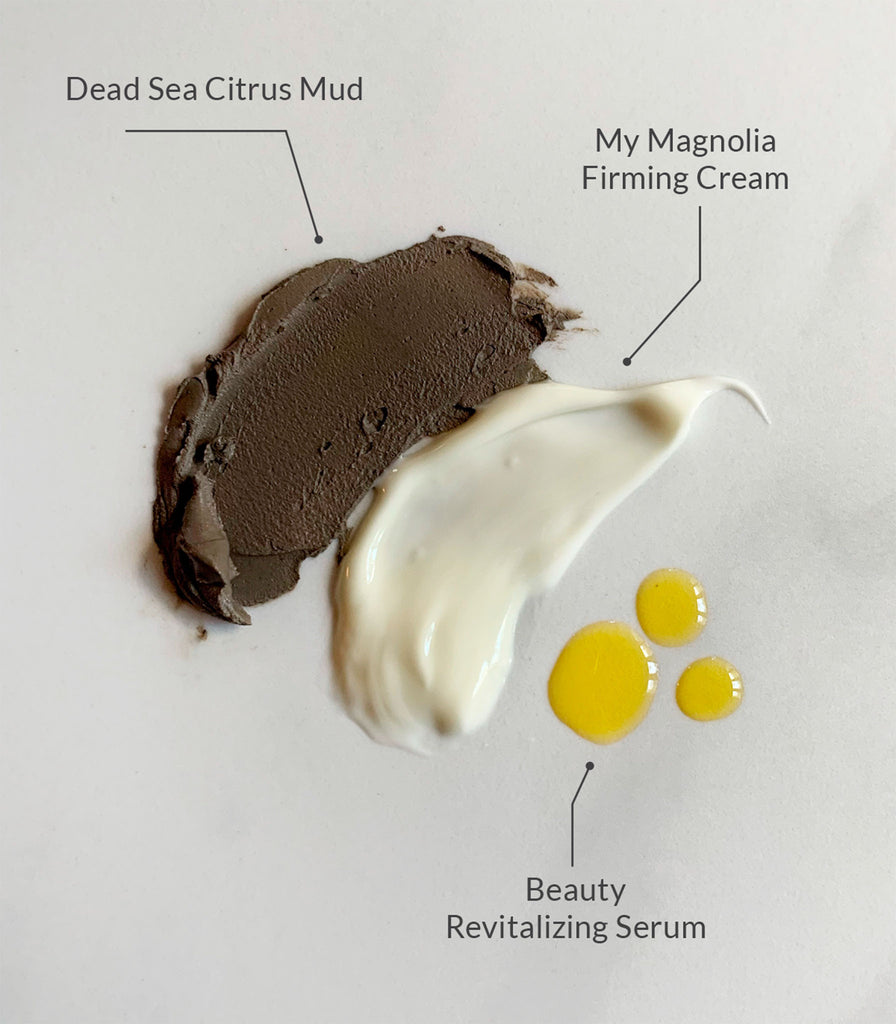 Product swatches of Dead Sea Citrus Mud, My Magnolia Firming Cream, and Beauty Revitalizing Serum on marble.