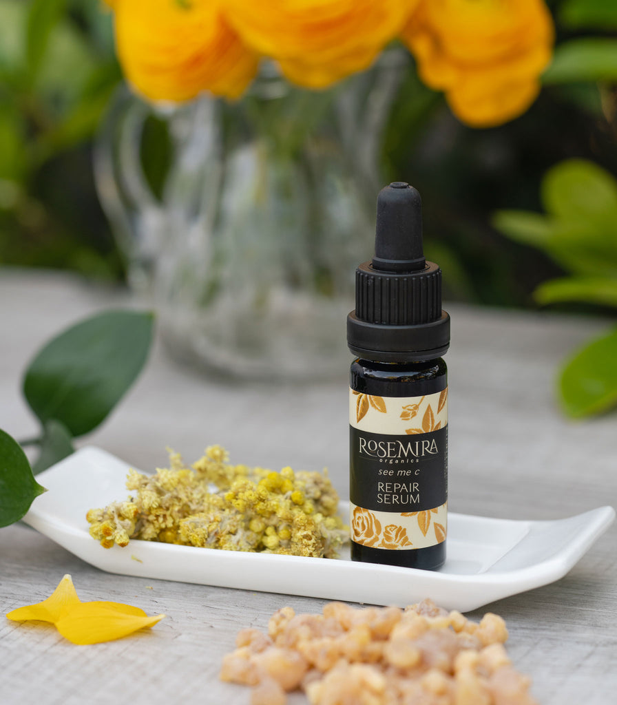 Vitamin C Serum on a white tray with dried flowers.