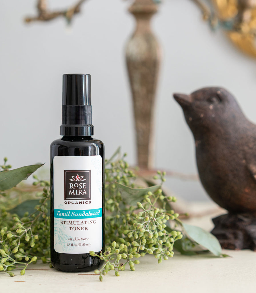 Tamil Sandalwood Stimulating Toner with green sprigs and a bird statue