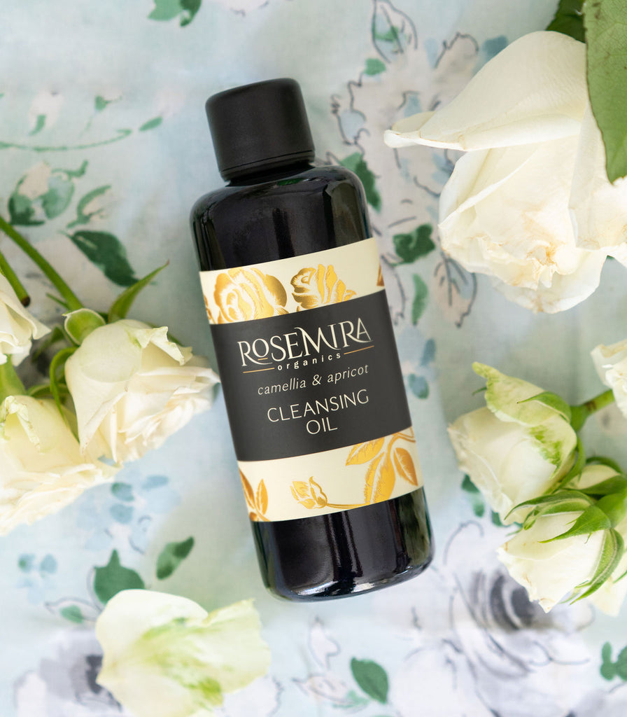 Organic cleansing oil with white roses and floral tablecloth