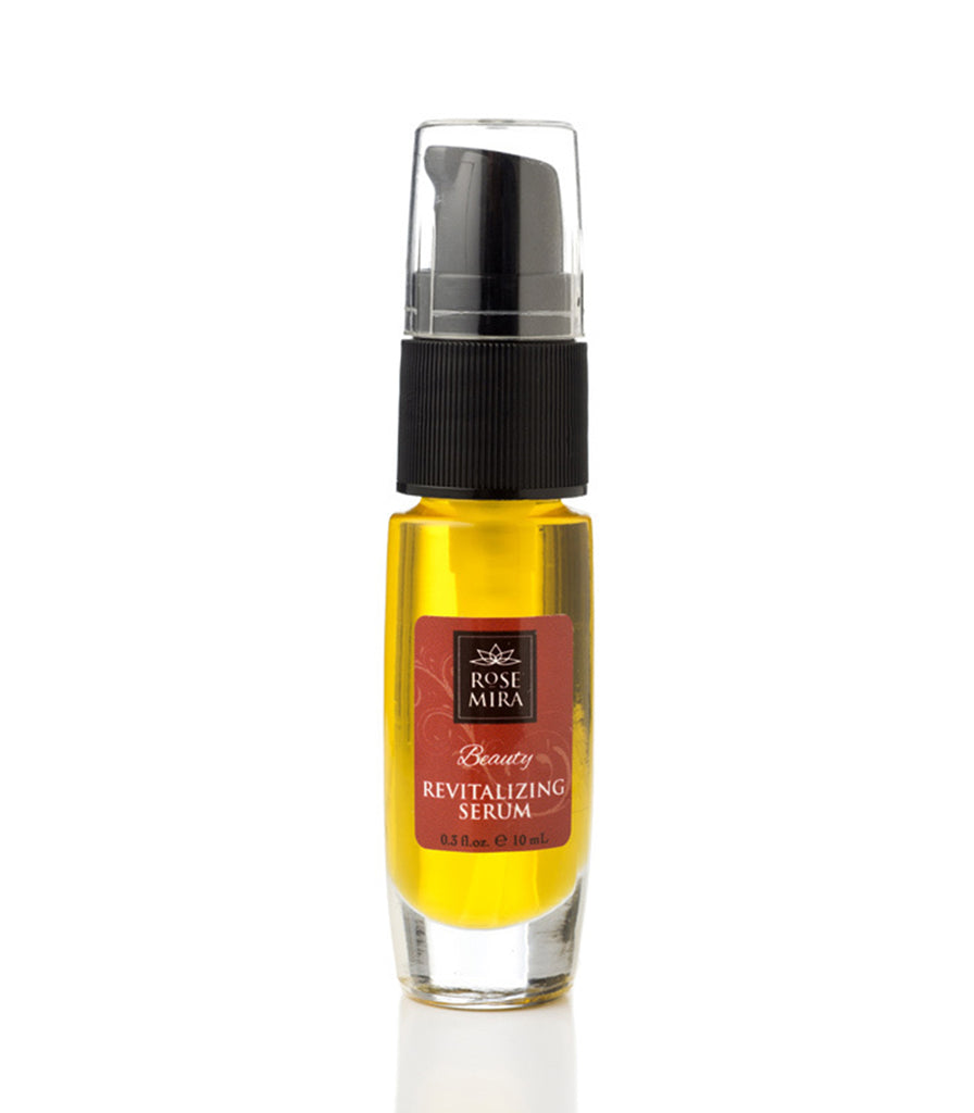 A clear bottle of the Rosemira Beauty Revitalizing Serum showing its golden color.