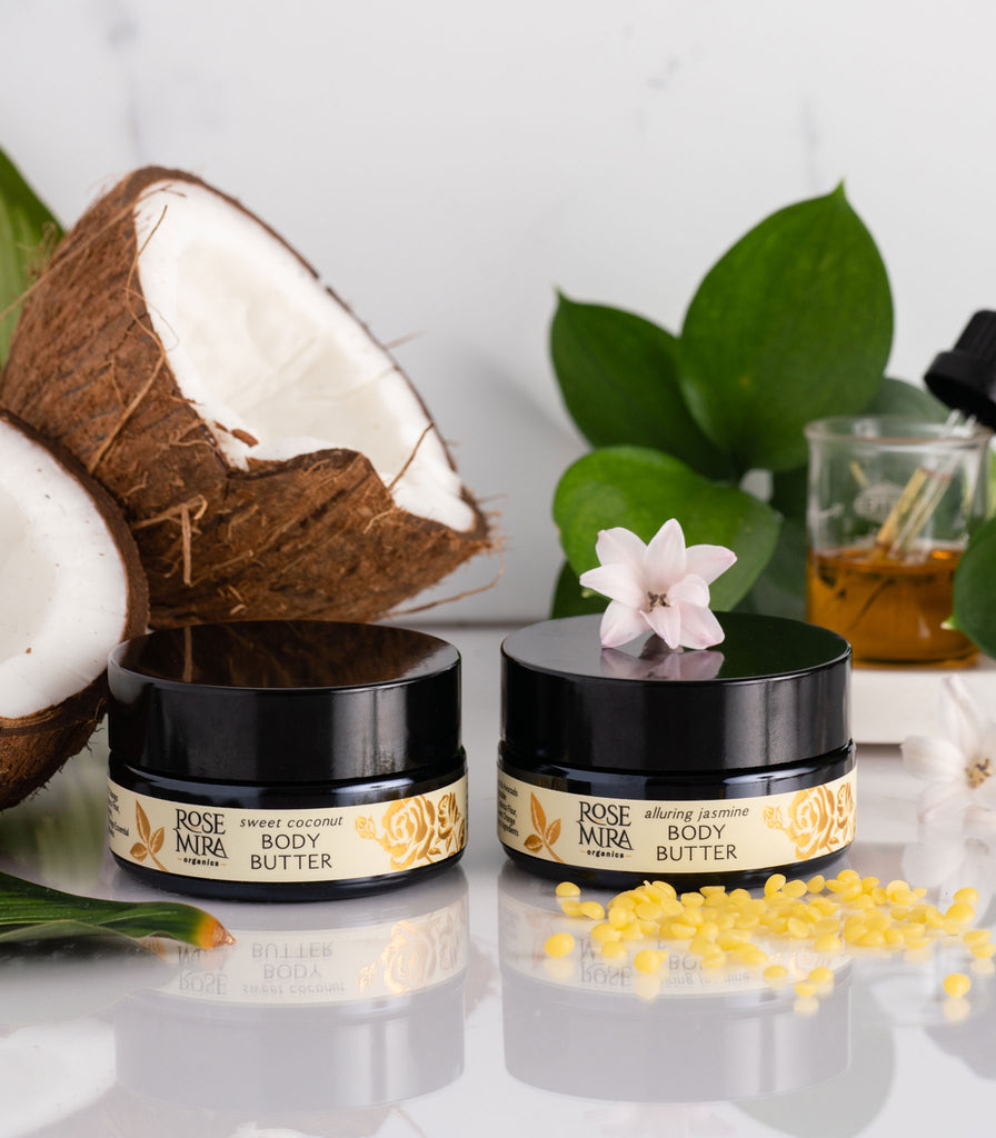 Two types of organic body butters with coconuts, green leaves, and serum beaker.