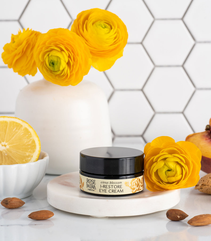 Citrus Eye Cream with yellow flowers, lemon slice, and scattered almonds.