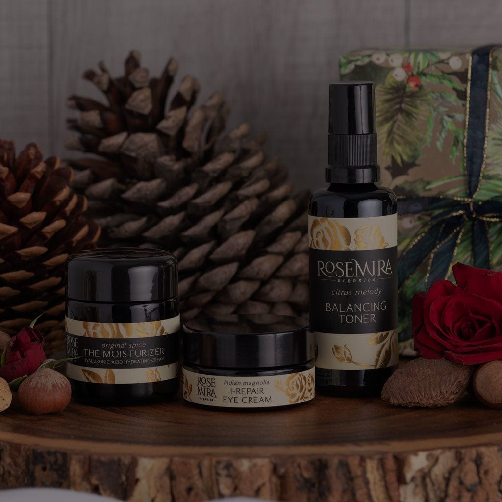 Rosemira skincare with gift wrapped present, pinecones, and roses.