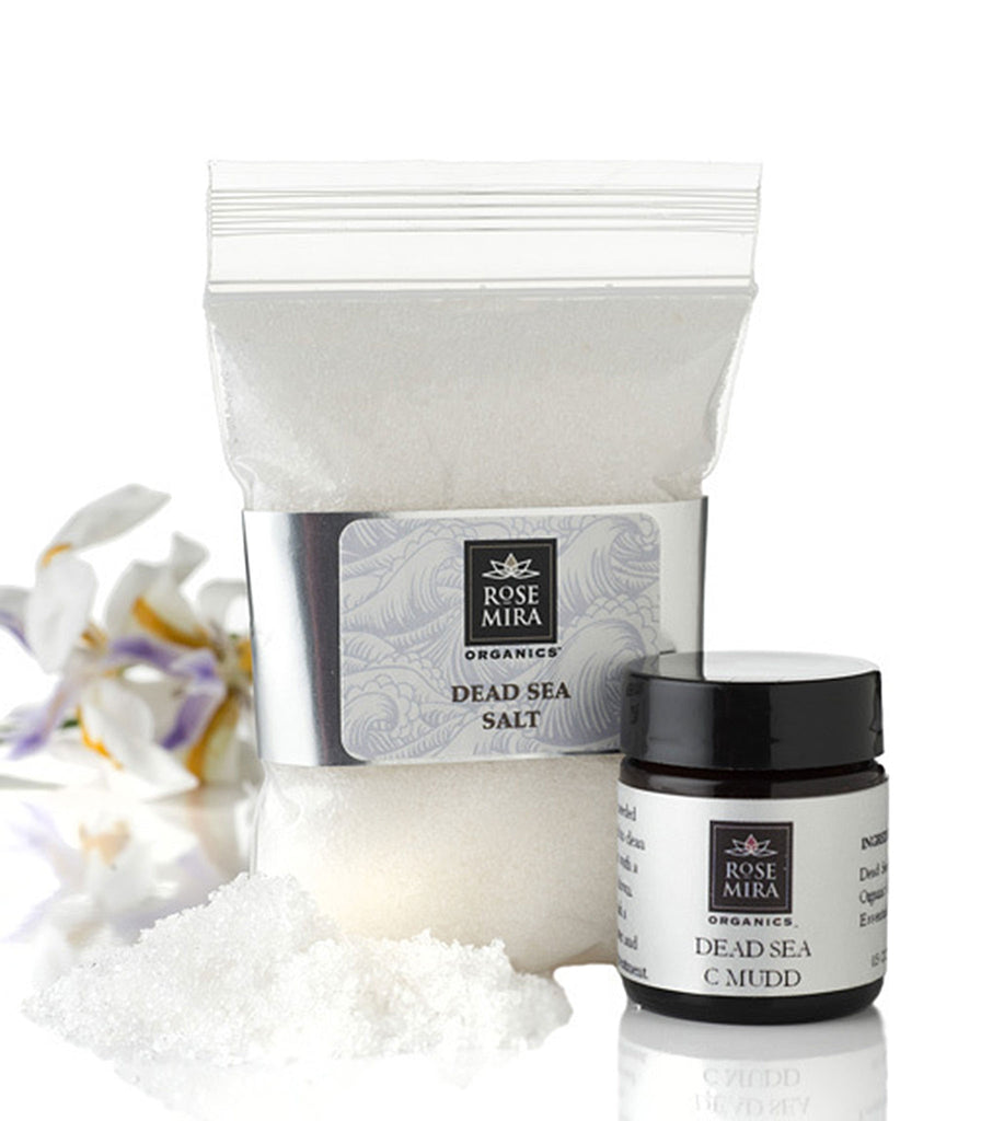 A bag of Dead Sea Salts and Dead Sea Citrus Mud with white and purple flower