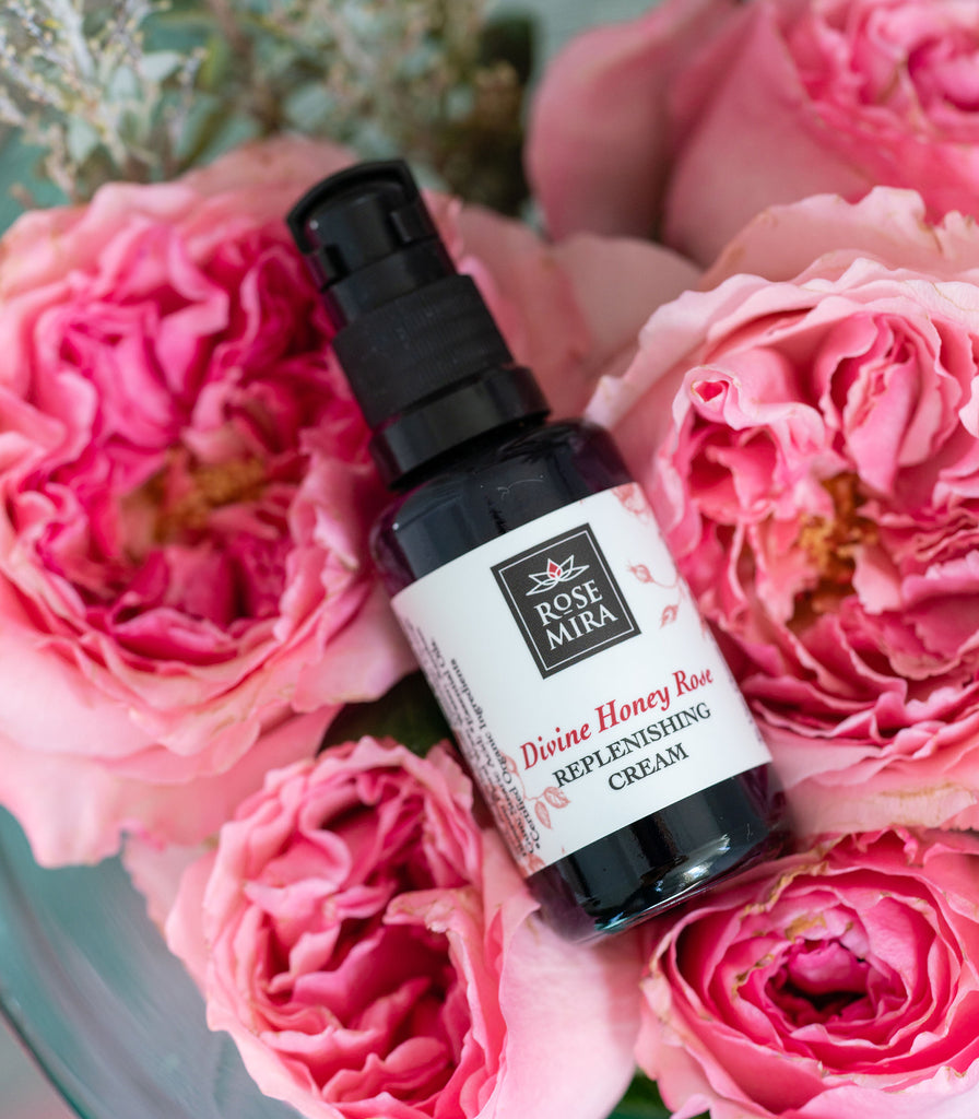 Divine Honey Rose Replenishing Cream in a bed of pink roses.