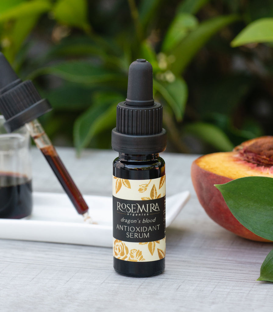 Dragon's Blood Antioxidant Serum with a dropper of serum and peach