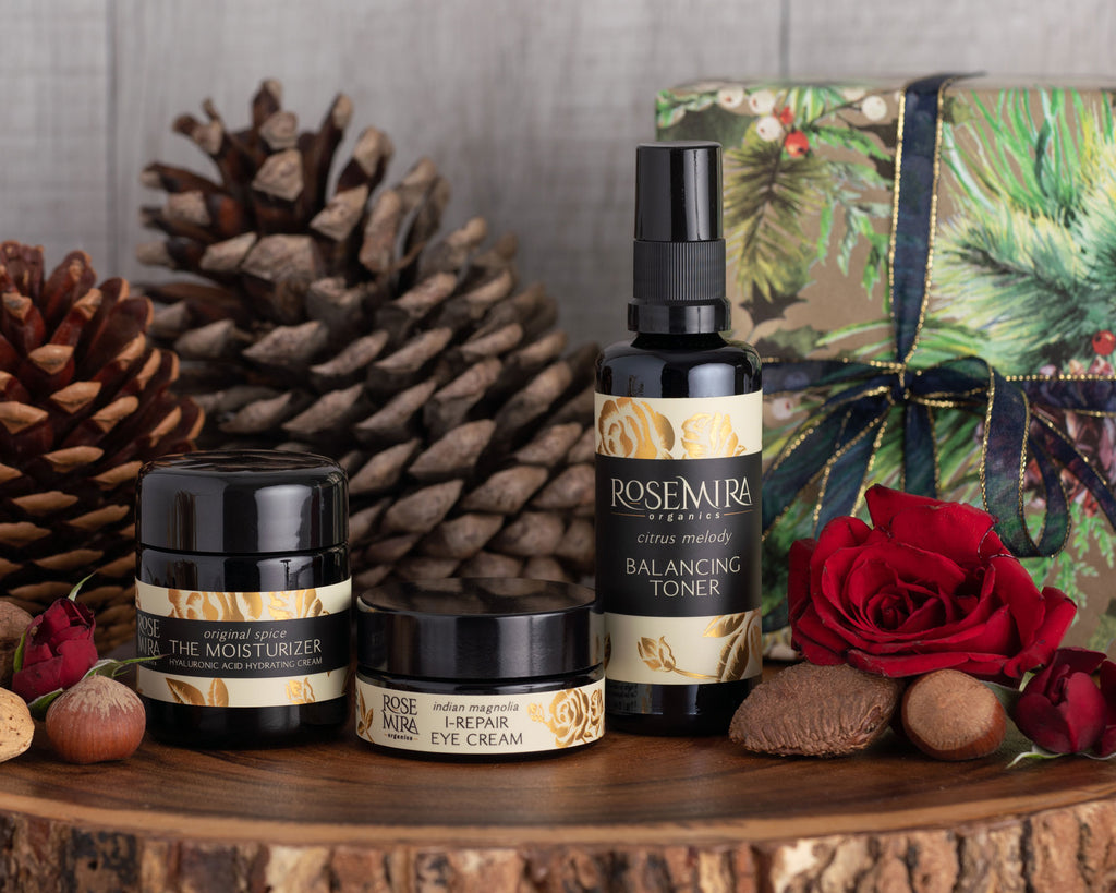 Three organic skincare bottles and a wrapped present for gift-giving.