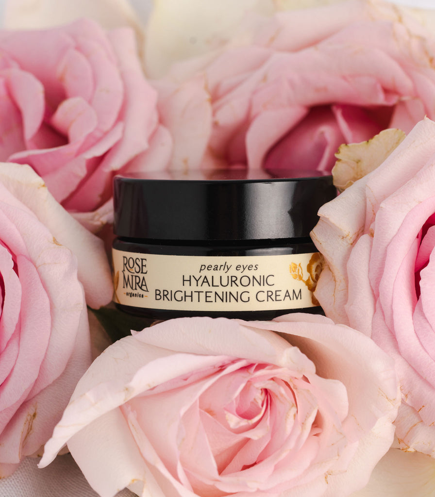 Hyaluronic Acid brightening eye cream nestled in a bed of pink roses.