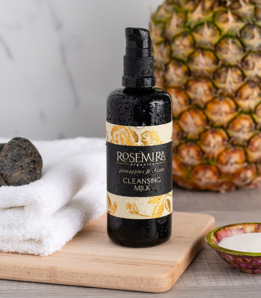 Organic cleansing milk on board with pineapple, clean towel.