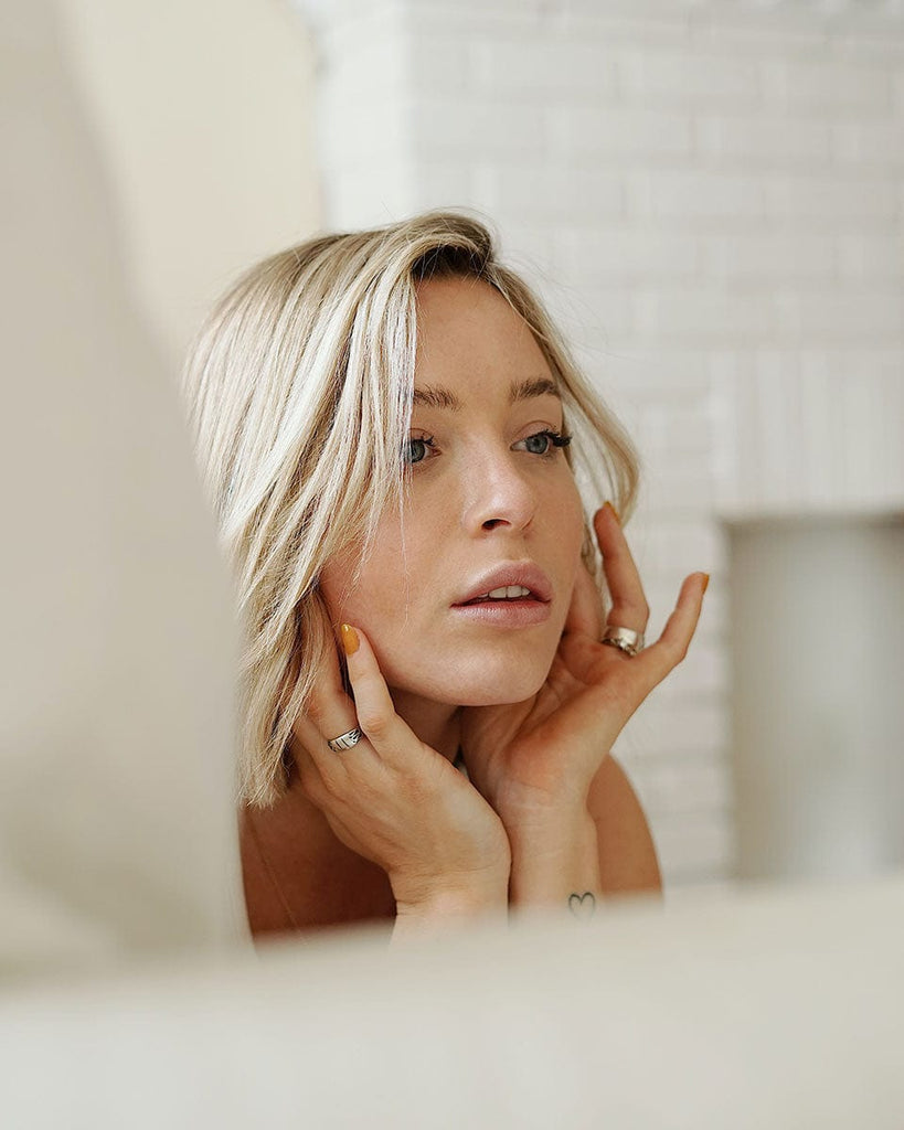 Gentle touch of hands on face while using Rosemira Skincare products