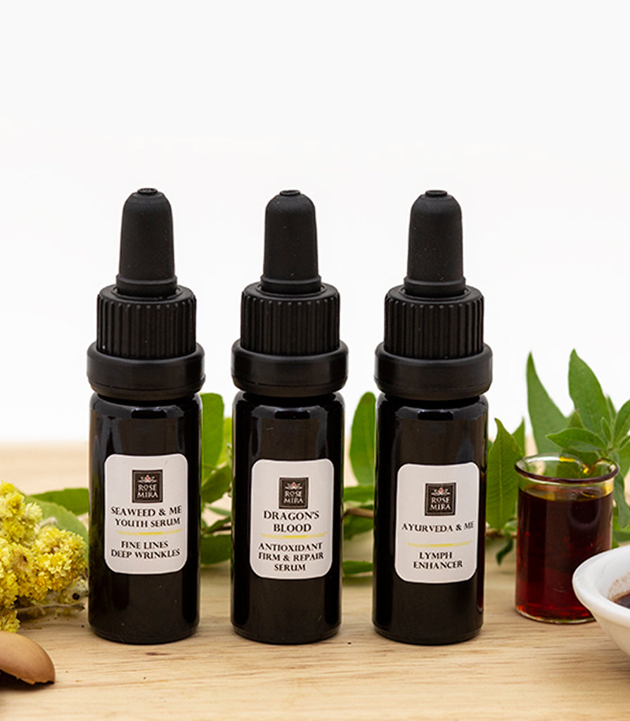 Seaweed and Me, Dragon's Blood, and Ayurveda and Me serums lined up with natural ingredients.