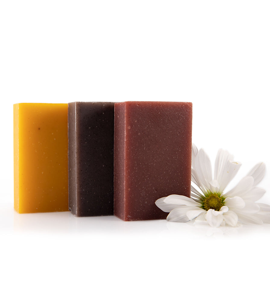 Three Rosemira plant-based soap bars with a white daisy prop