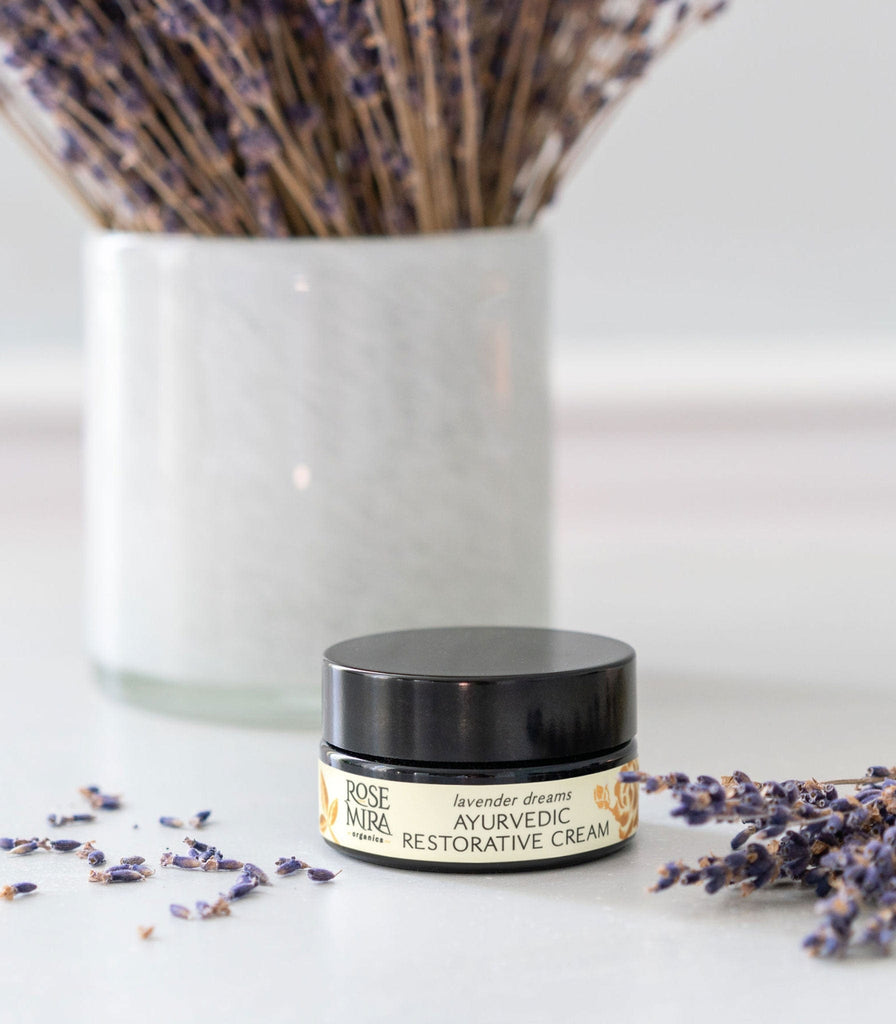 Rosemira Restorative Cream with a bundle of lavender in a white vase.